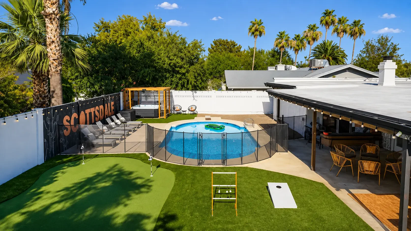 Sunny backyard with pool, hot tub, putting green and lawn games