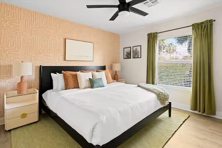 King bedroom with patterned accent wall and green curtains — The Sunkiss, Scottsdale, Arizona