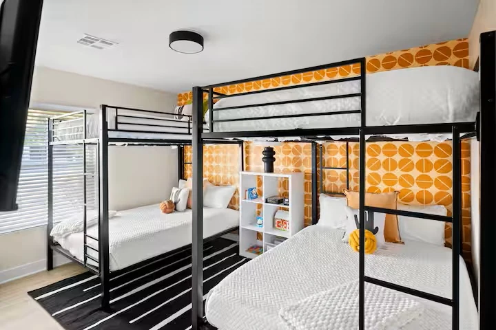 Bunk room with four beds and orange retro wallpaper